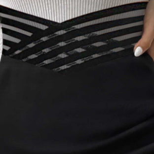 Close-up of black fabric detail from an asymmetric hem skirt for women with striped accents