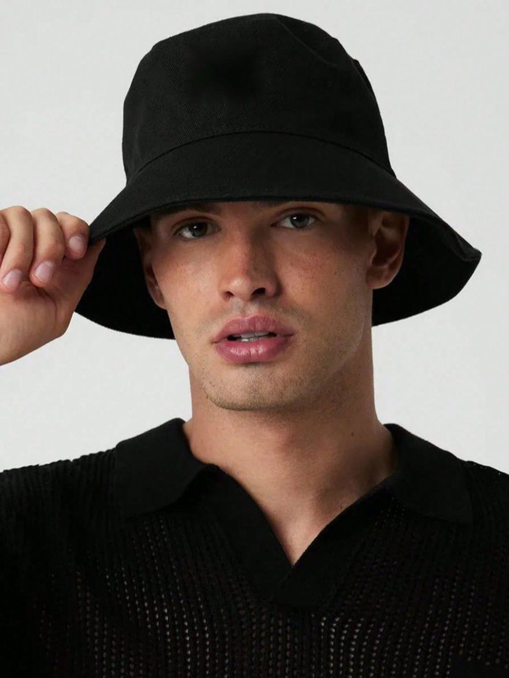 Man wearing black cotton wide brim bucket hat with casual black shirt