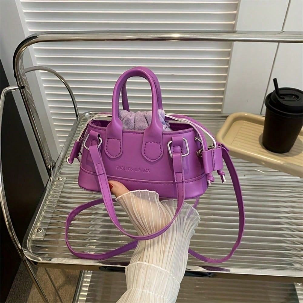 Purple elegant top handle clutch bag by LUNIVA CARE USA held on metal rack with long strap