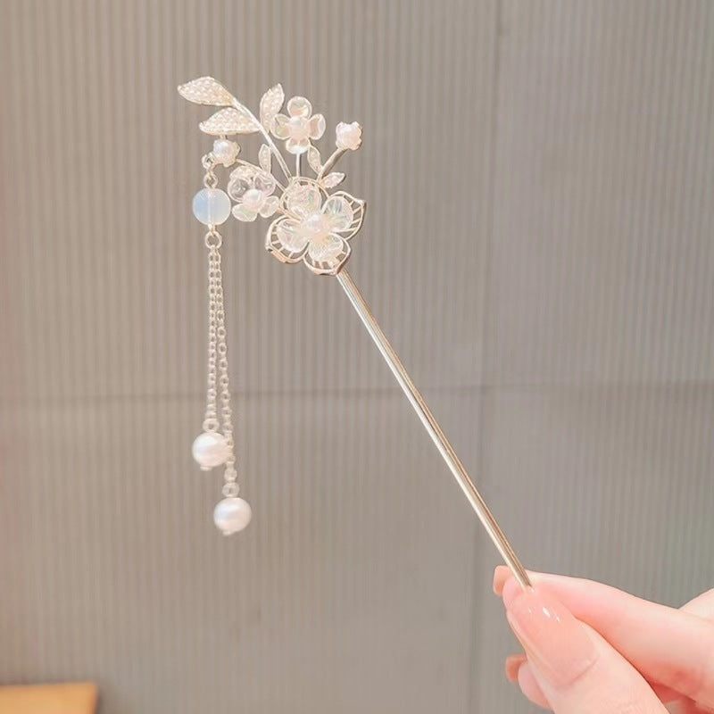 Luxury hair stick for special occasions with delicate floral design and dangling pearls held by hand