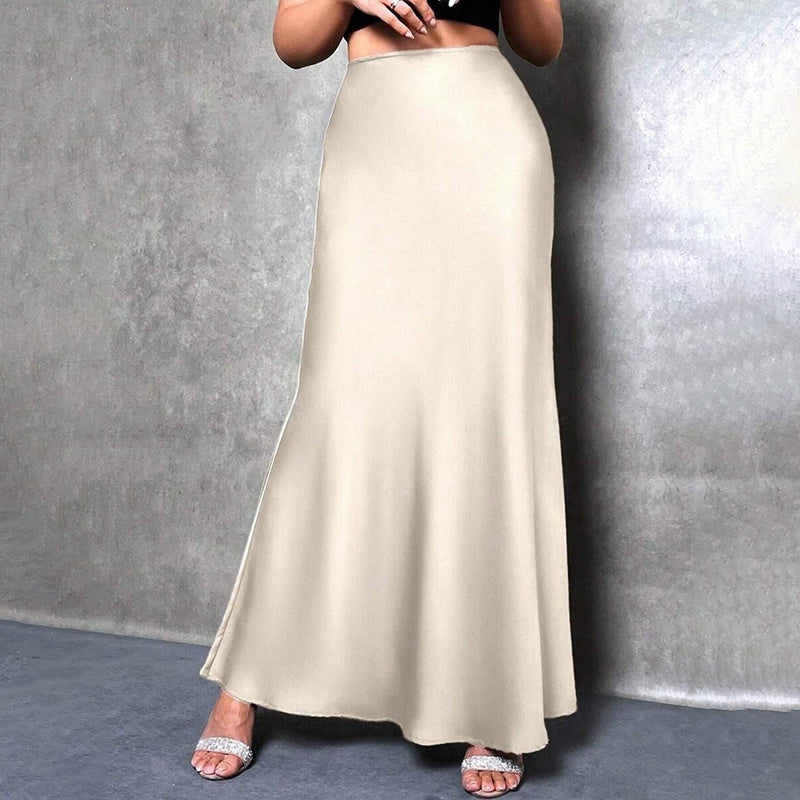 Elegant satin midi skirt in ivory color worn with silver open-toe heels on a gray background