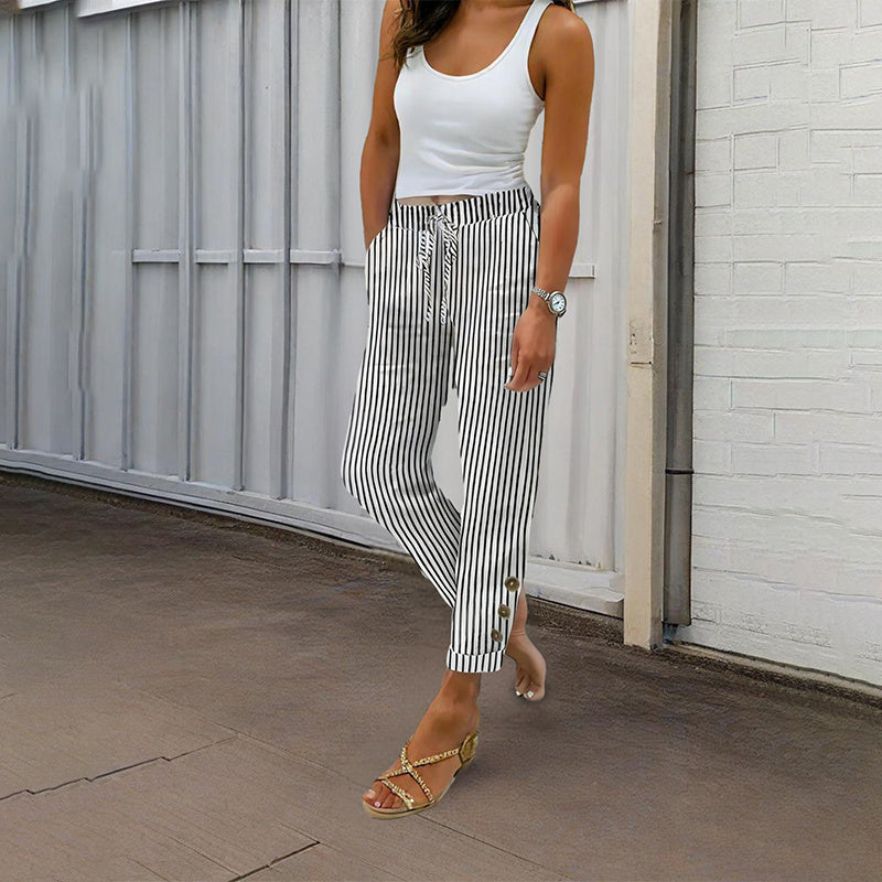 Woman wearing women's striped elastic waist pants with vertical black and white stripes and button details