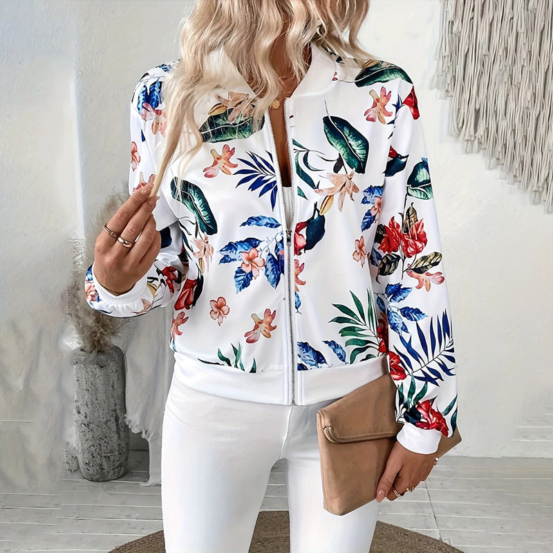 Women's botanical print zip-up jacket with colorful floral design and white base worn with white pants