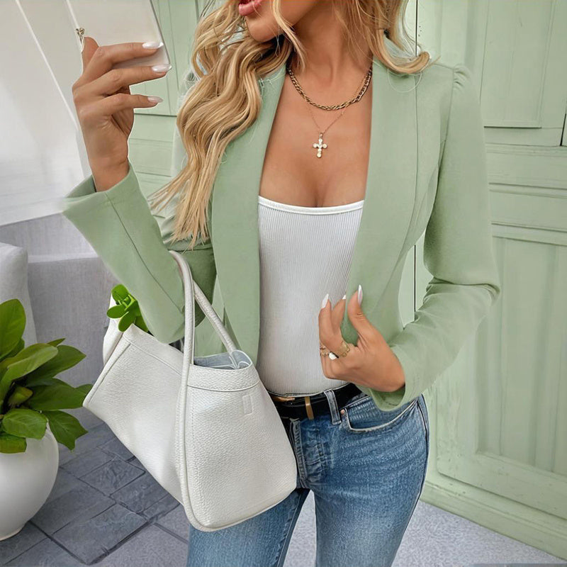 Light green women's casual blazer jacket styled with white top blue jeans and white handbag