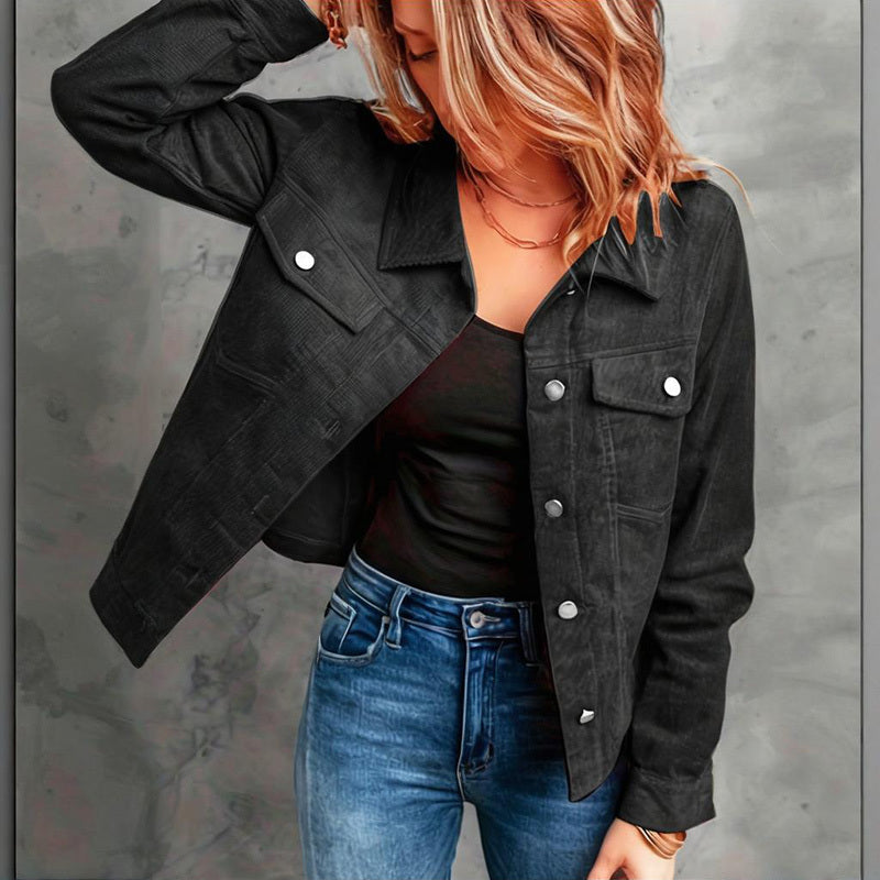 Black women's corduroy jacket with silver buttons worn over black top and blue jeans
