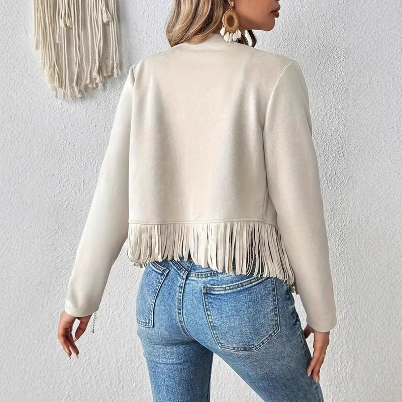 Back view of a woman wearing a cream women's fringe suede jacket paired with blue jeans