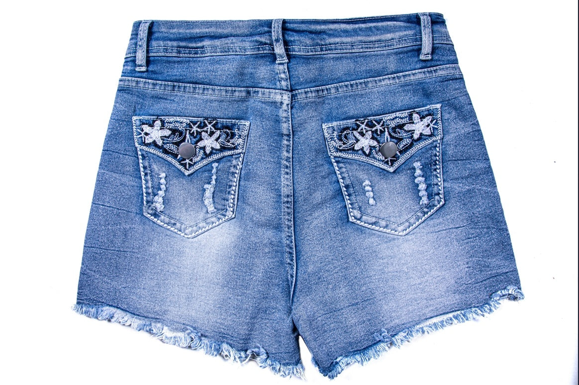 Back view of womens ripped jean shorts with frayed hems and embroidered floral back pockets