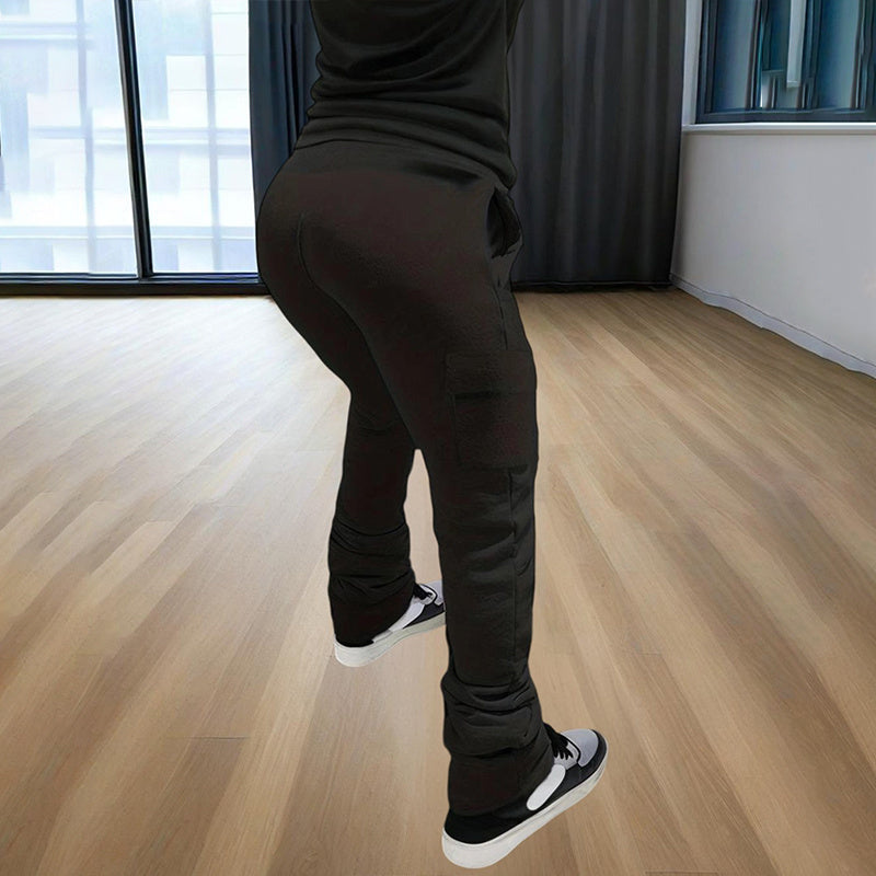 Black women's straight leg pants worn with black and white sneakers in a bright room