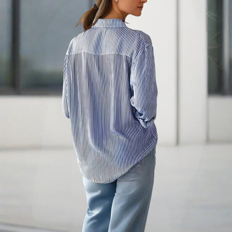 Back view of a woman wearing a women's striped button-up shirt paired with light blue pants
