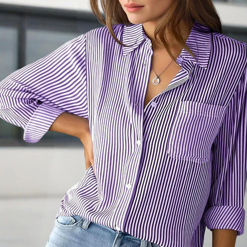 Close-up of a woman wearing a purple and white women's striped button-up shirt paired with light blue jeans