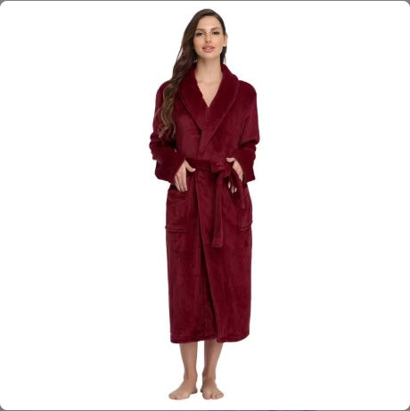 Woman wearing a long burgundy women's winter flannel bathrobe with pockets and belt standing barefoot