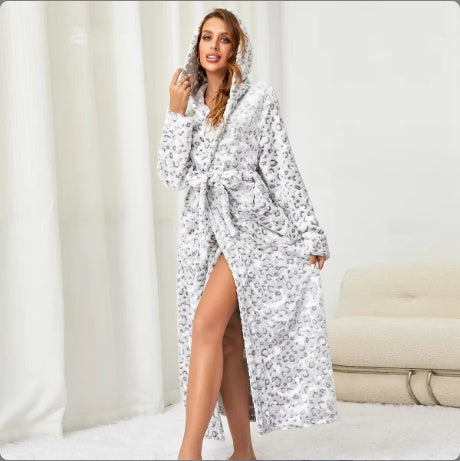 Woman wearing a cozy white and grey leopard print women's winter flannel bathrobe with a hood and waist tie