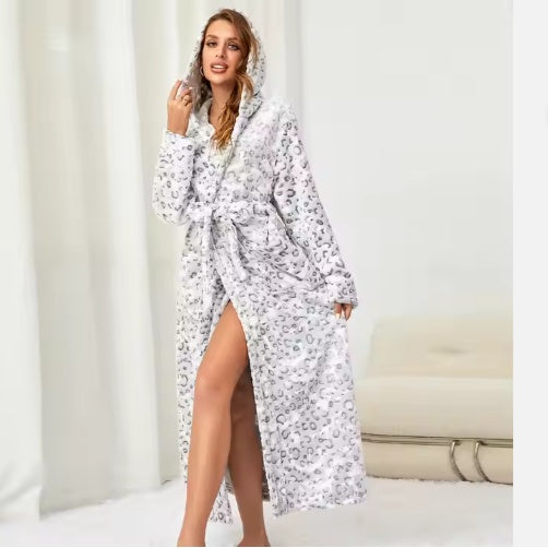 Woman wearing a white leopard print women's winter flannel bathrobe with hood and belt