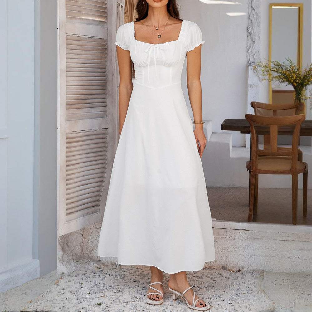Woman wearing a white bohemian backless maxi dress with short sleeves and square neckline