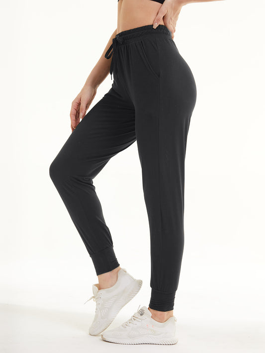 Woman wearing dark gray cropped sweatpants with an elastic waistband and side pockets