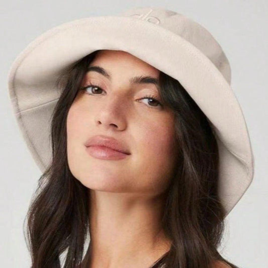 Woman wearing a beige cotton wide brim bucket hat with soft fabric and casual style