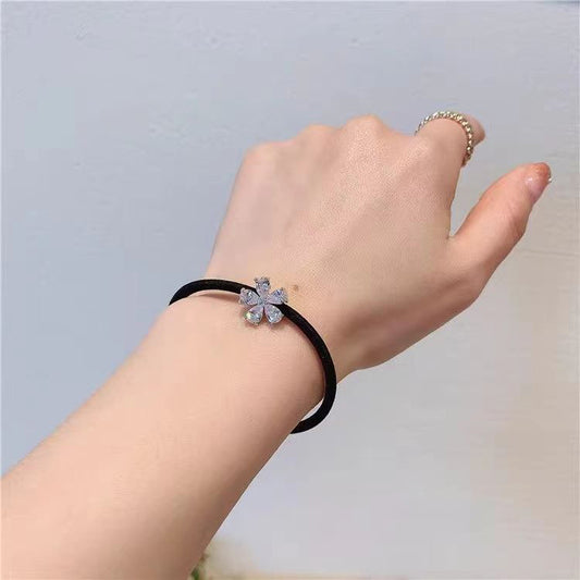 Delicate crystal flower hairband for women by LUNIVA CARE USA shown on wrist with black band and sparkling flower detail