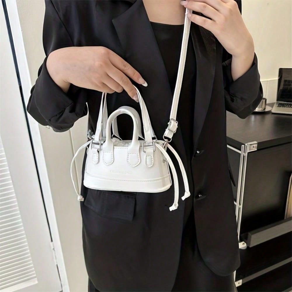 LUNIVA CARE USA elegant top handle clutch bag in white mini crossbody style worn with black outfit
