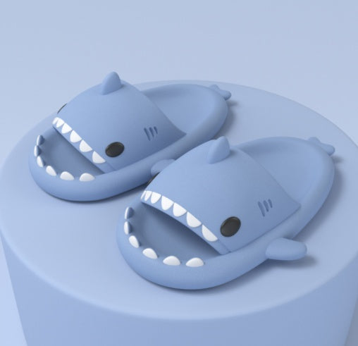 Light blue funny shark slippers for adults with teeth and fins design on a round display