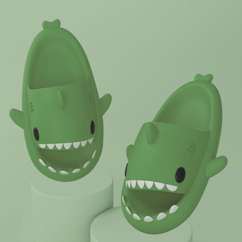 Green funny shark slippers for adults with playful teeth and fin design on a matching green background