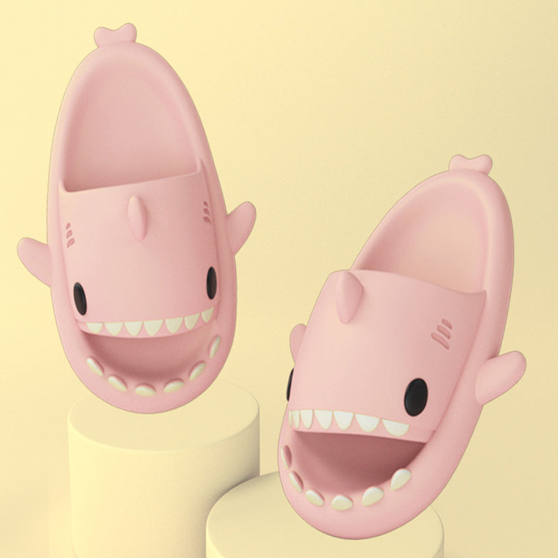 Pink funny shark slippers for adults with cute teeth and fin design on beige background