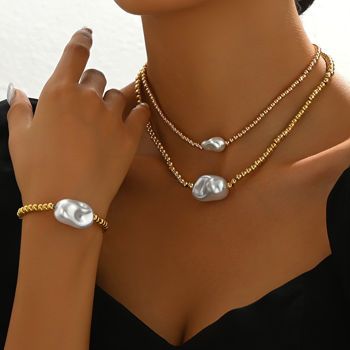 Handmade gold layered jewelry set with gold beads and pearl-like accents on necklaces and bracelet