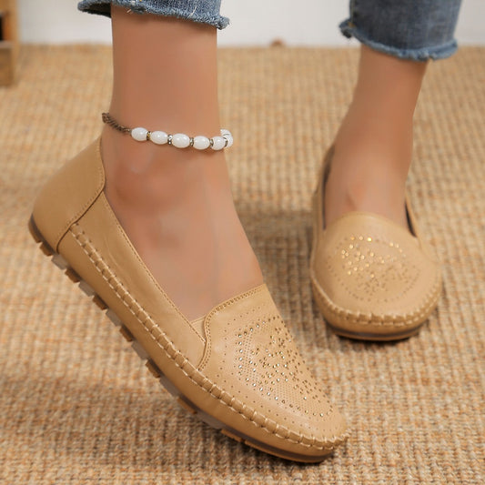 Tan handmade women's casual shoes with perforated design and stitched sole worn with jeans