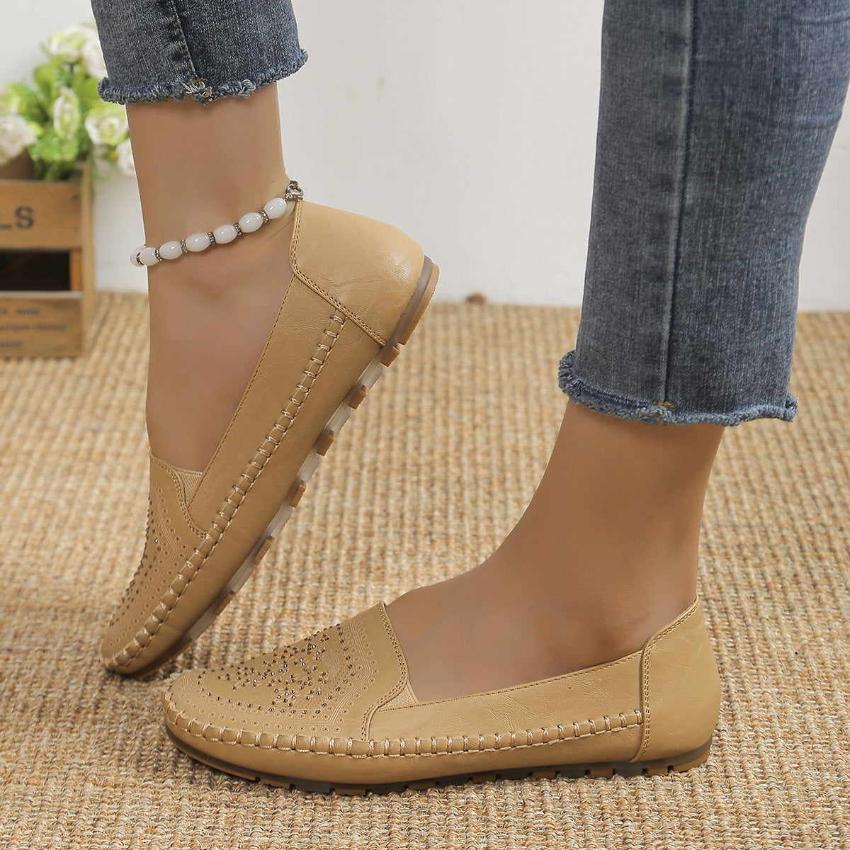 Beige handmade women's casual shoes with stitched detailing and soft sole worn with ankle bracelet and jeans