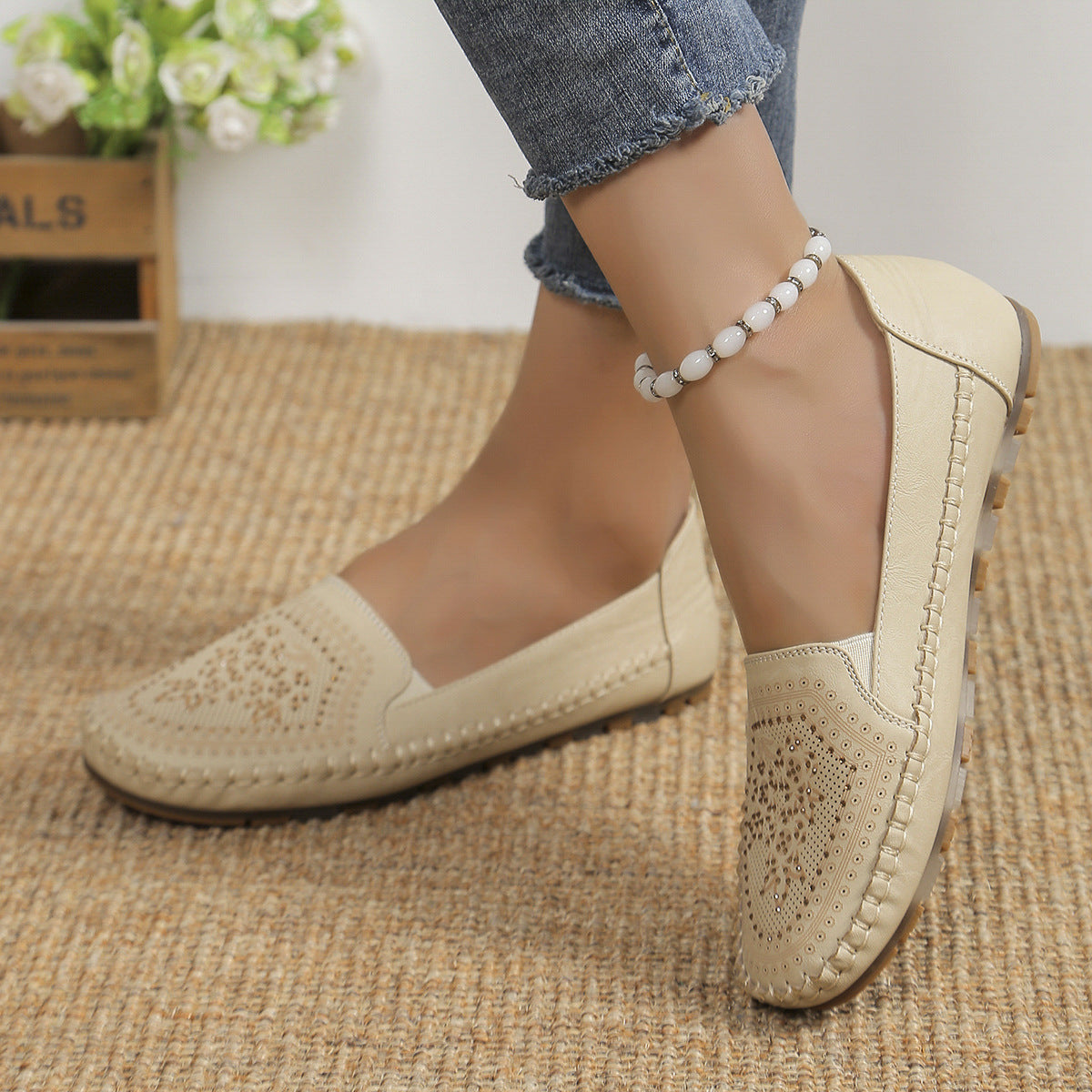 Beige handmade women's casual shoes with perforated design and stitched detailing worn with ankle bracelet