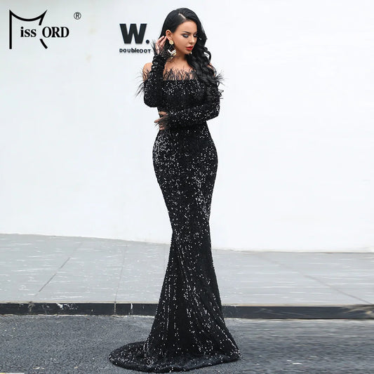 Woman wearing elegant black off shoulder sequin maxi dress with long sleeves and fitted silhouette