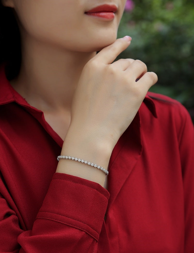 Elegant S925 fine jewelry bracelet with moissanite stones worn on wrist by woman in red blouse