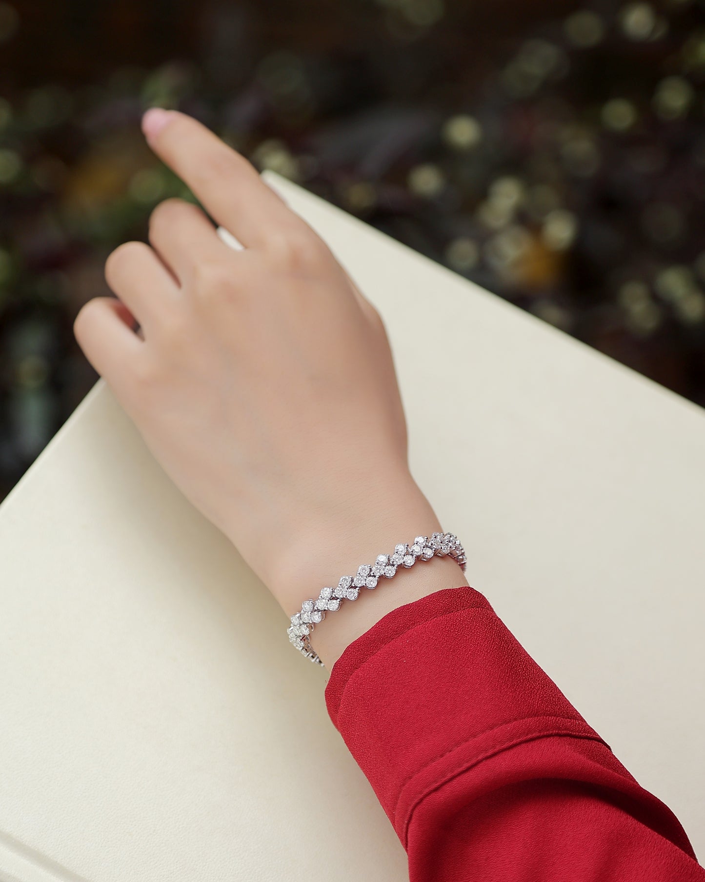 Elegant S925 silver moissanite bracelet worn on wrist with red sleeve background
