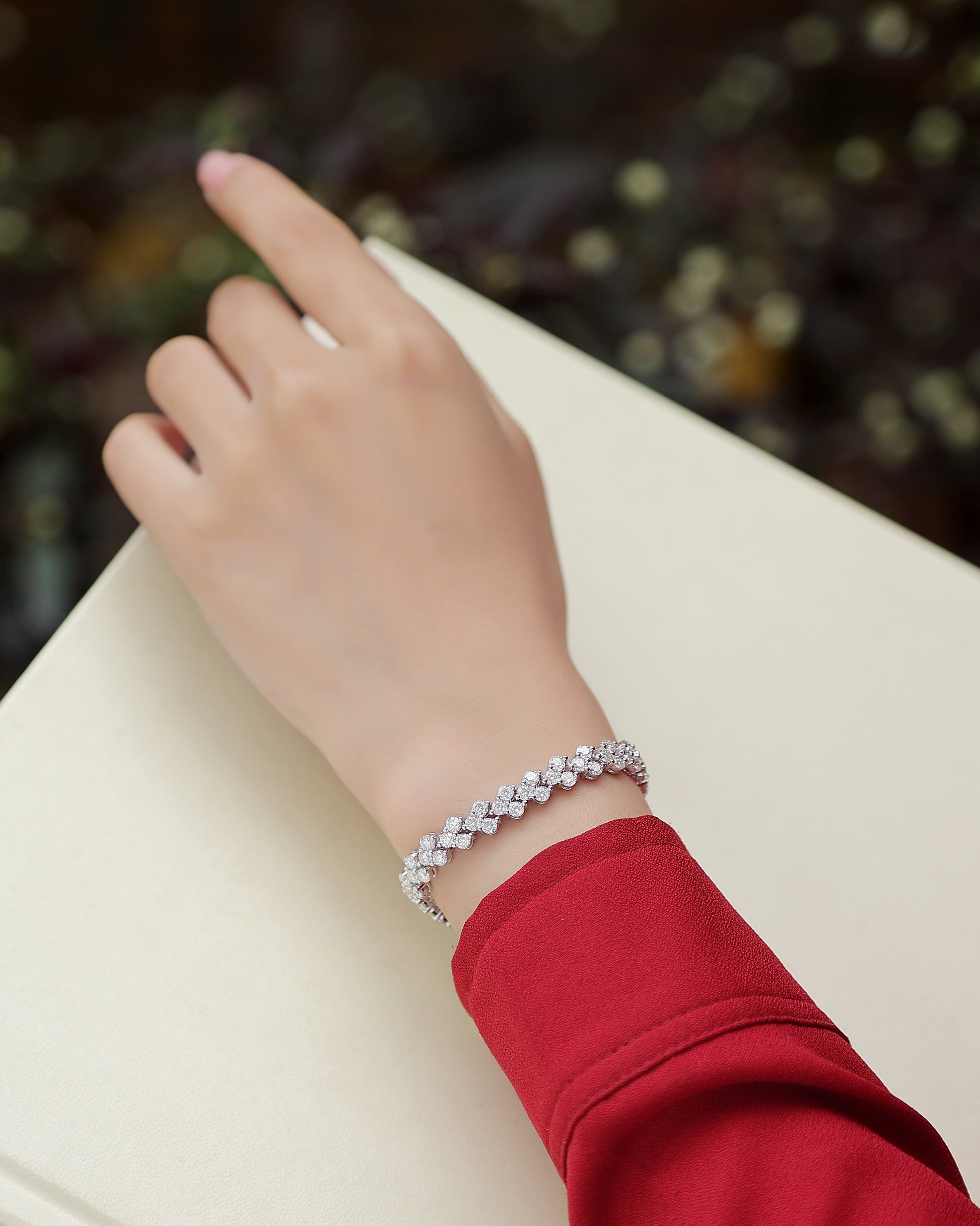 Elegant S925 silver moissanite bracelet worn on wrist with red sleeve background