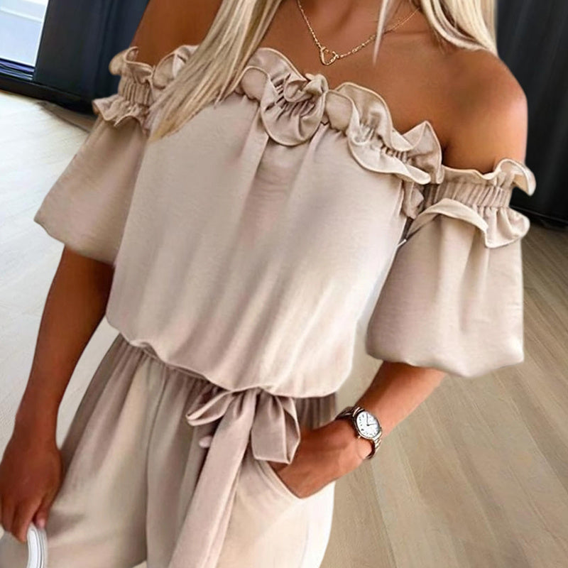 Woman wearing an elegant off-shoulder jumpsuit for women in beige with ruffled neckline and tied waist