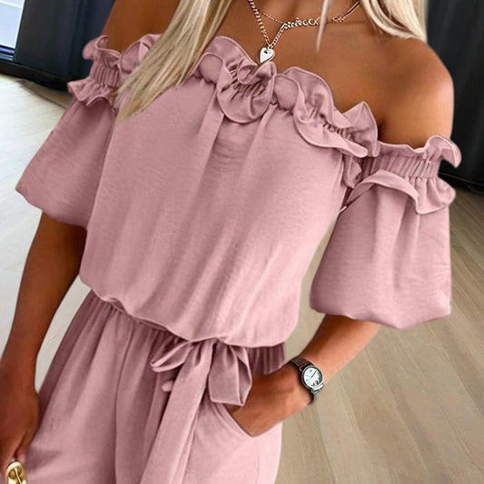 Close-up of a woman wearing an elegant off-shoulder jumpsuit for women in soft pink with ruffled sleeves and waist tie