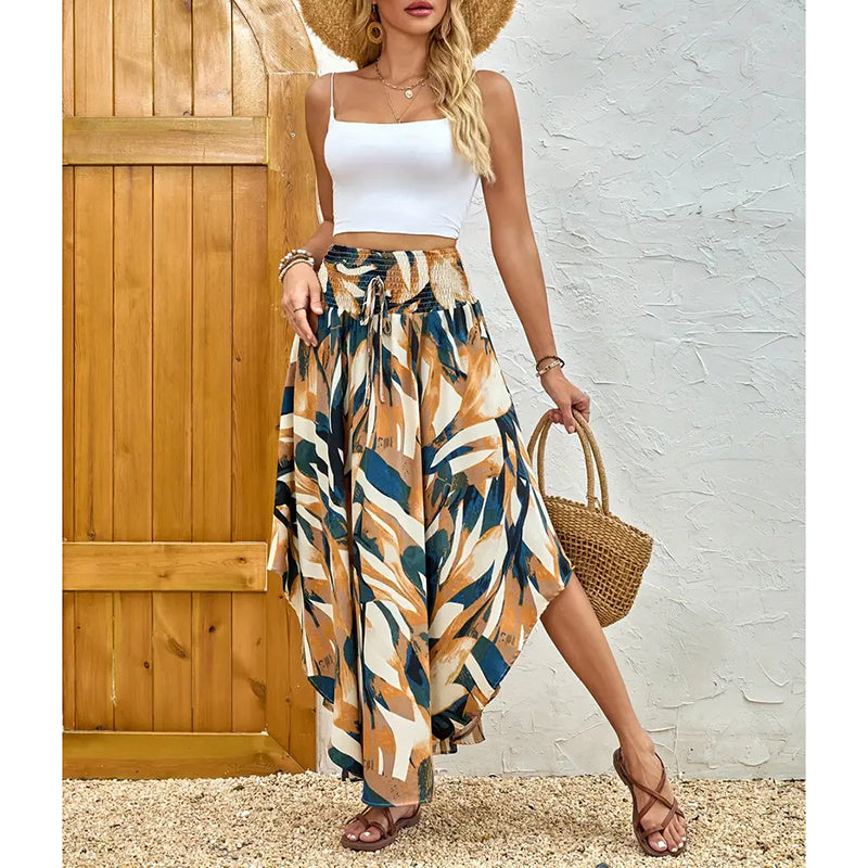 Woman wearing high waist floral midi skirt with abstract leaf print paired with white crop top and straw hat