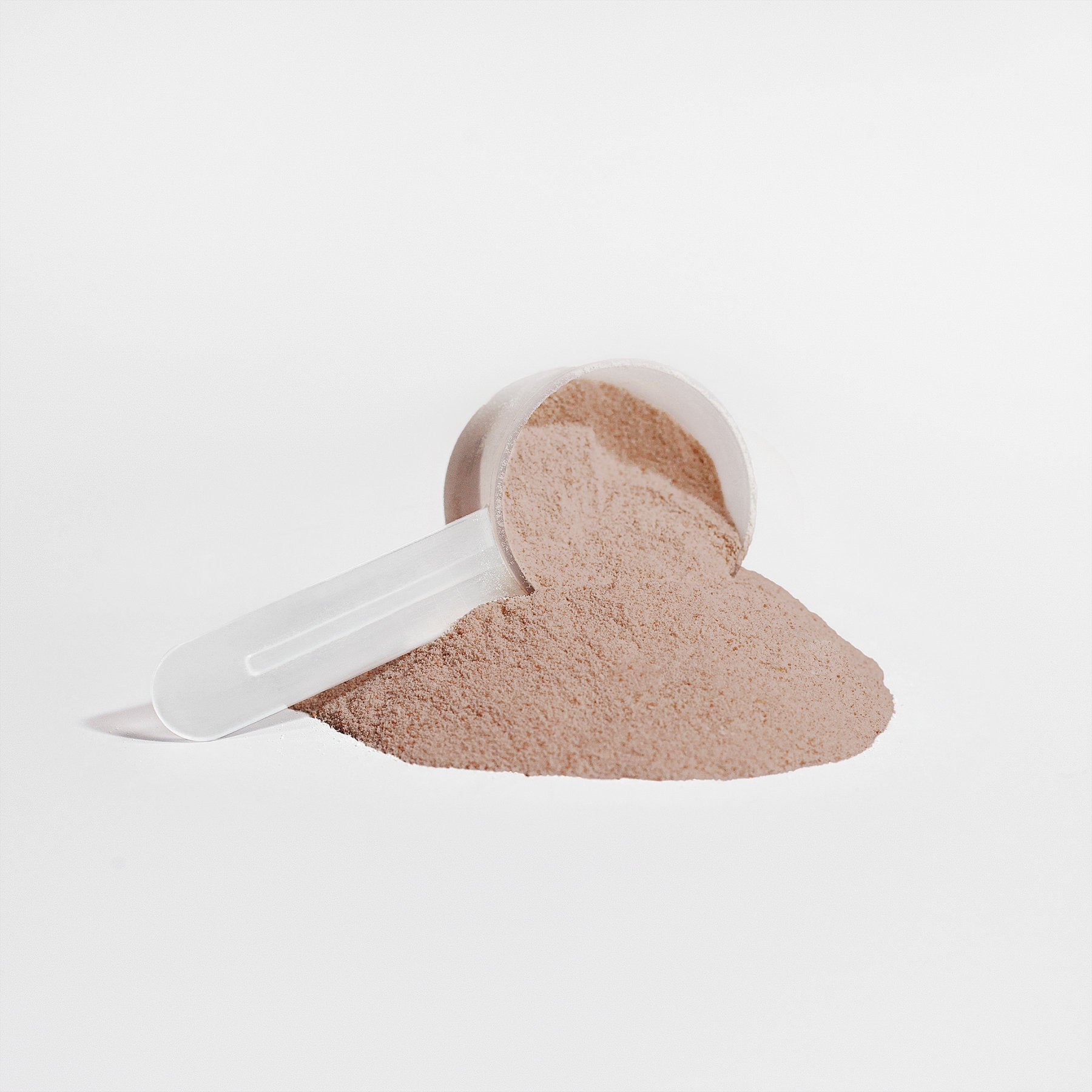 Scoop of plant-based protein powder chocolate in white measuring scoop on white background