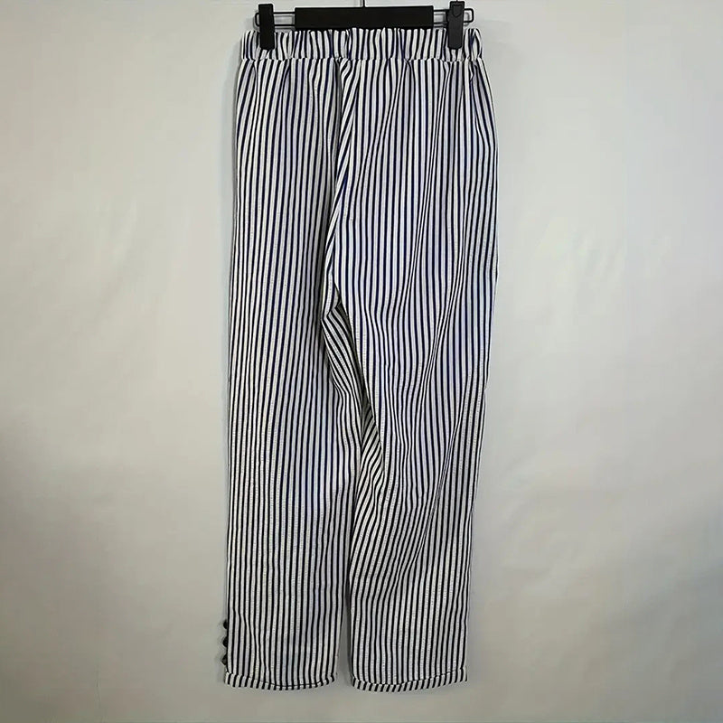 Women's striped elastic waist pants in white with black vertical stripes hanging on a black hanger