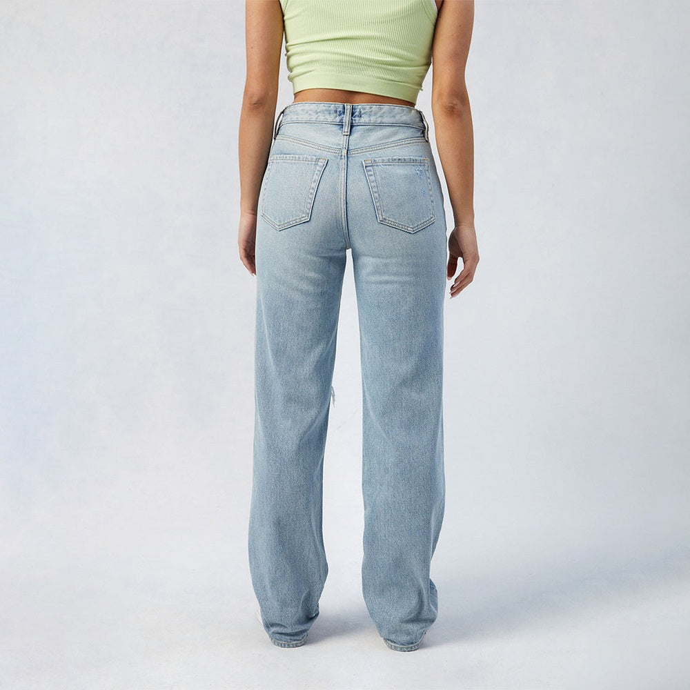 Back view of women's high-waist wide leg jeans in light blue denim worn with a green crop top