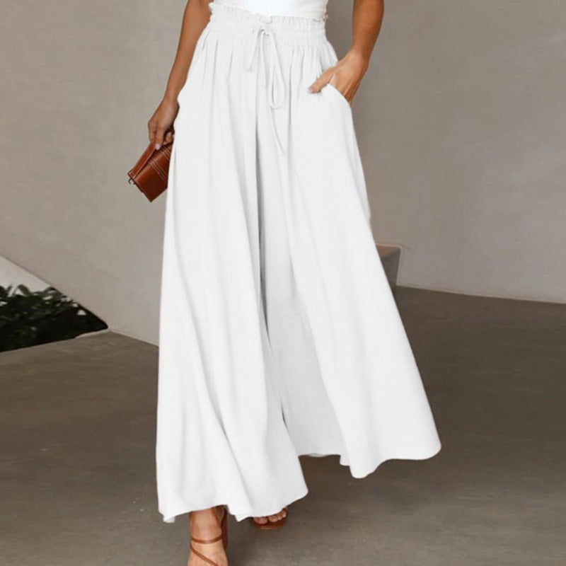 White women's high waist wide leg pants with drawstring and pockets styled with brown clutch and sandals