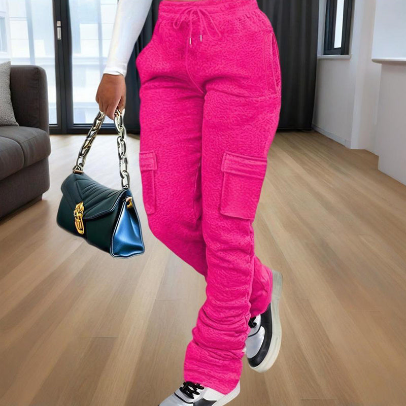 Bright pink women's straight leg pants with cargo pockets styled with white sneakers and a black handbag