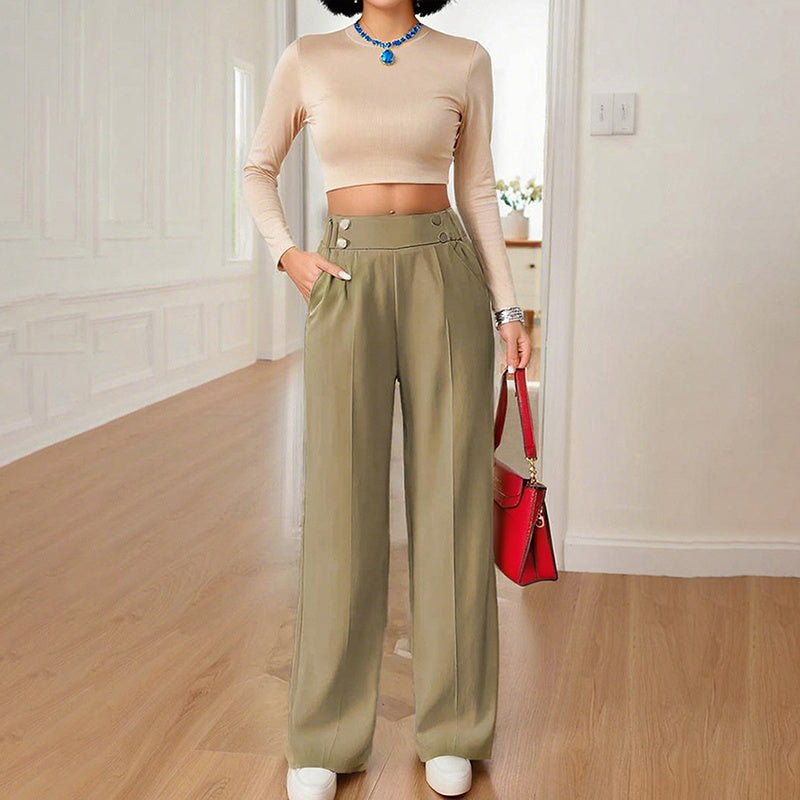 Woman wearing women's wide leg business trousers in olive green paired with beige crop top and red handbag